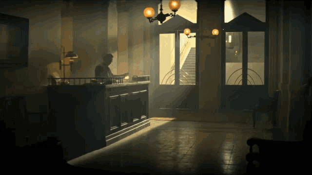 a dark room with a man standing at a counter