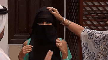 a woman wearing a veil is being helped by a man .