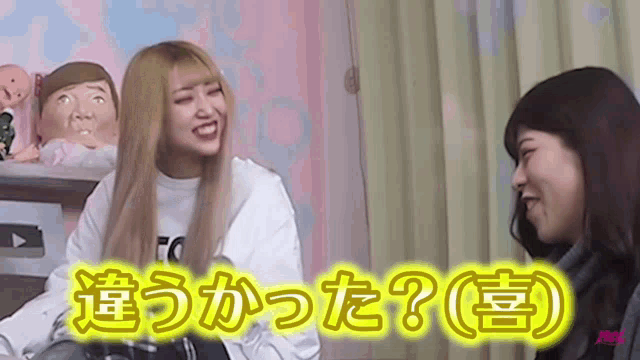 two women are sitting next to each other and one of them is wearing a white shirt that says ' to ' on it