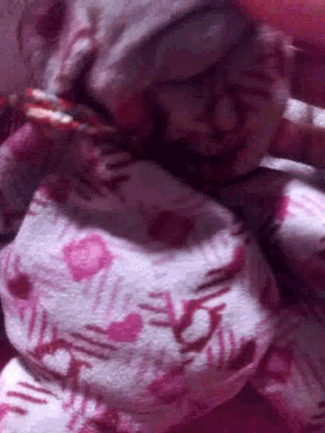 a close up of a pink blanket with hearts on it .