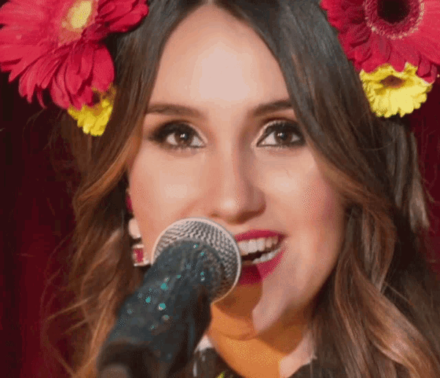 a close up of a woman singing into a microphone
