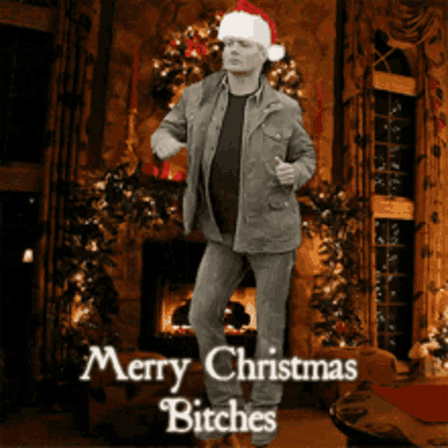 a man in a santa hat is dancing in front of a fireplace with the words merry christmas bitches