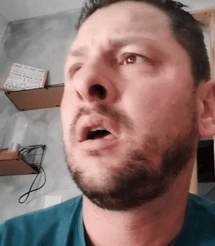 a man with a beard is wearing a blue shirt