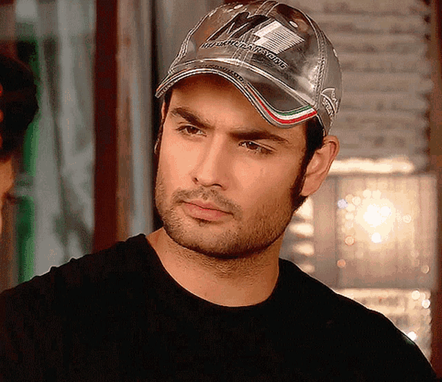 a man wearing a baseball cap that says ' ferrari ' on it