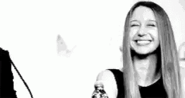 a black and white photo of a woman laughing .