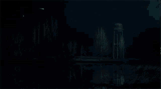 a water tower in the middle of a dark forest at night