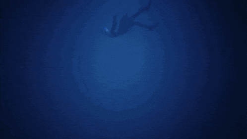 a silhouette of a person swimming in a dark blue ocean