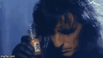 a close up of a man holding a bottle of beer .