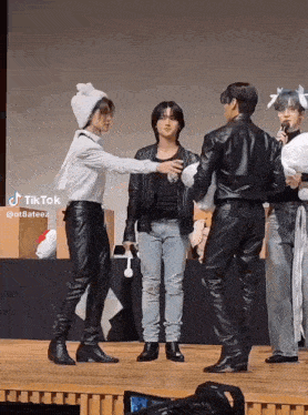 a group of men are standing on a stage with one wearing a bunny hat