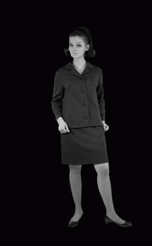 a black and white photo of a woman in a black suit