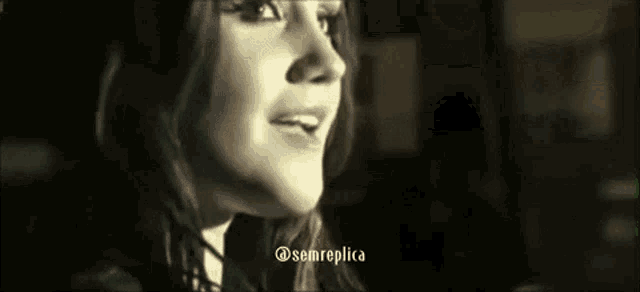 a close up of a woman 's face in a black and white photo with the caption `` sem replica '' .