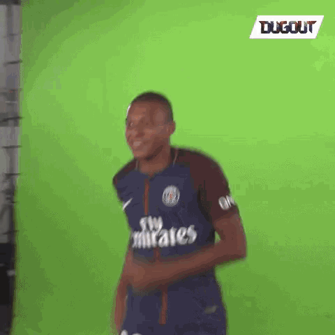 a soccer player is standing in front of a green screen .