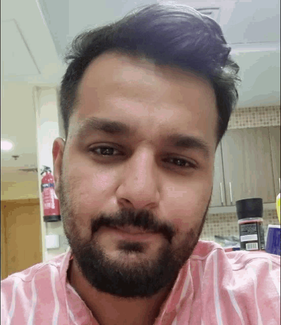a man with a beard wearing a pink striped shirt