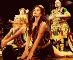 a group of people in costumes are dancing on a stage .