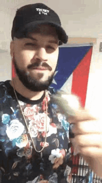 a man with a beard is wearing a hat and holding a bunch of money .
