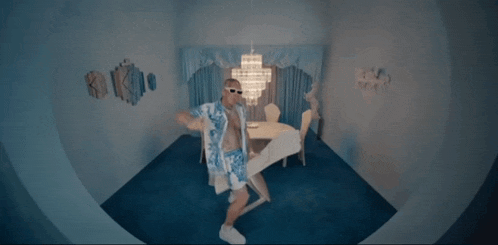 a man dancing in a room with a chandelier