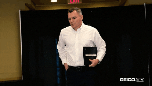 a man standing in front of an exit sign
