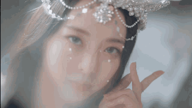 a close up of a woman 's face with a tiara on her head