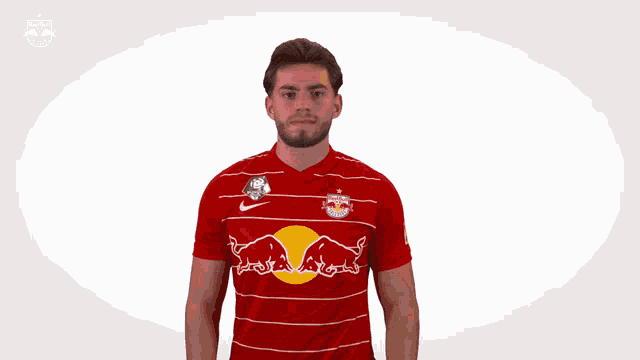 a man is wearing a red and white striped shirt with a red bull on it