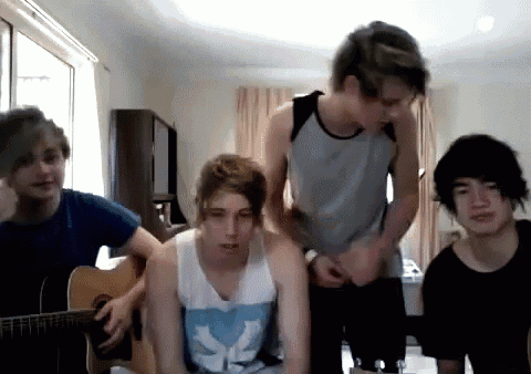 a group of young men are playing a guitar together