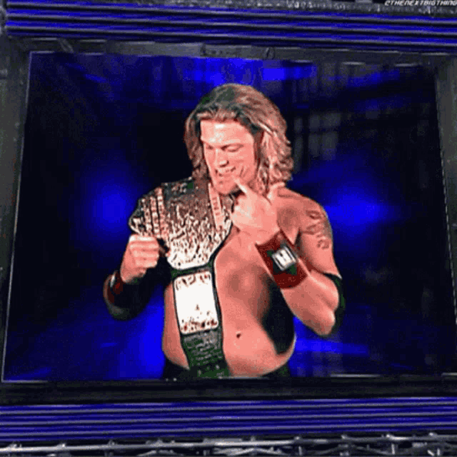 a shirtless wrestler is holding a wrestling championship belt