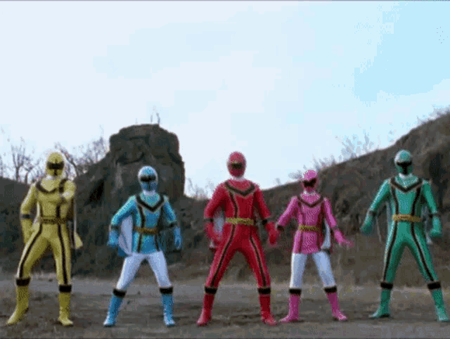 a group of power rangers standing next to each other in a field .