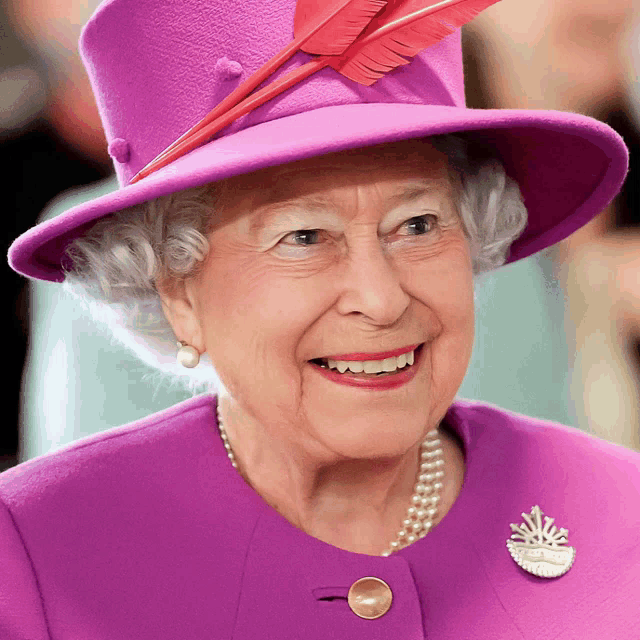 queen elizabeth wearing a purple hat and pearls smiles