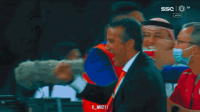 a group of soccer players are hugging each other in front of a ssc advertisement