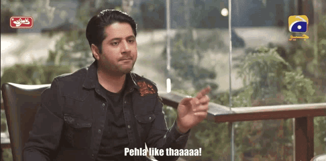 a man sitting in a chair with the words pehla like thaaaa on the screen behind him
