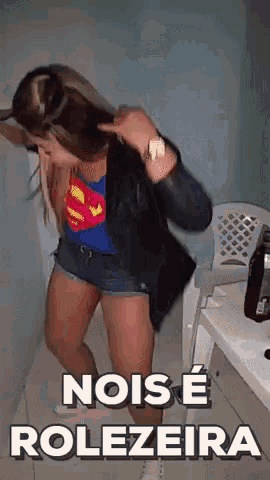 a woman in a superman costume is dancing with the words " nois e rolezeira " behind her