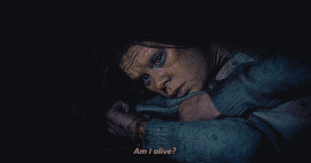 a woman in a dark room asking if she is alive