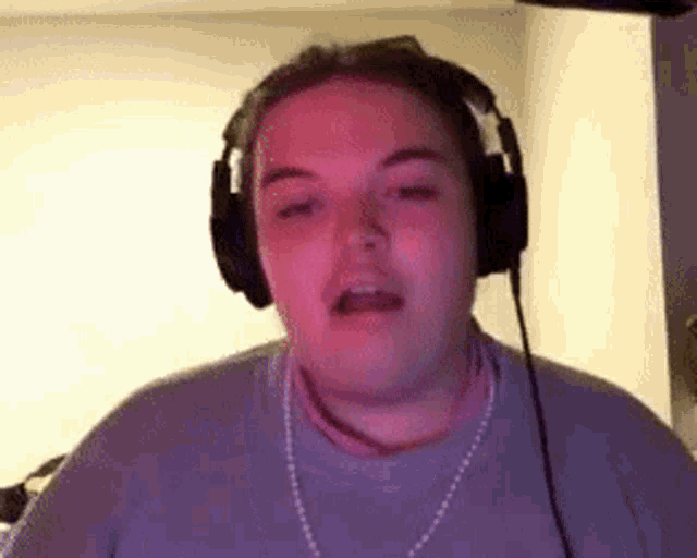 a woman wearing headphones is making a funny face while looking at the camera .