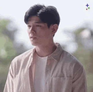 a young man wearing a white shirt and a white t-shirt is looking at the camera .
