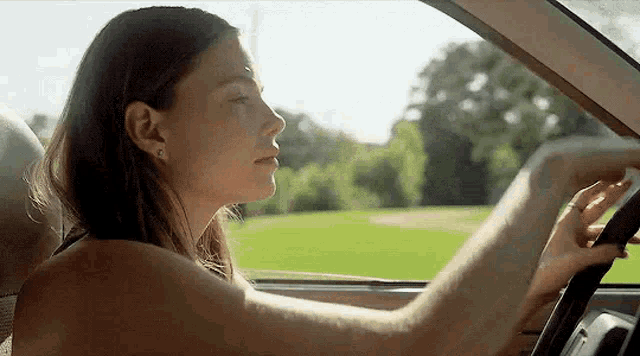 a woman is sitting in the driver 's seat of a car .