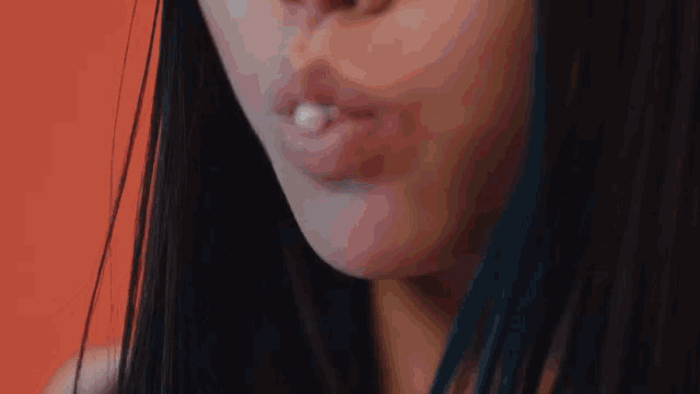 a close up of a woman 's mouth with a pearl in her mouth