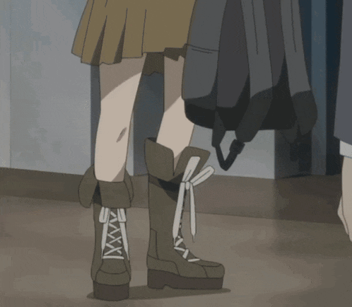 a person wearing a pair of brown boots with laces