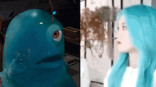 a woman with blue hair is standing next to a blue monster .