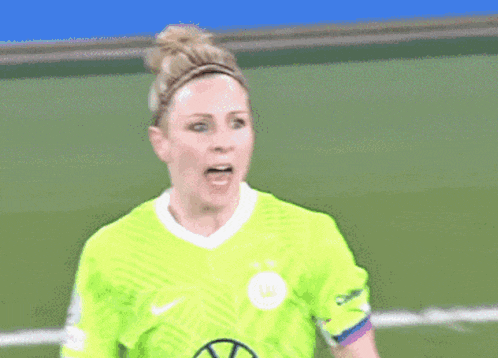 a female soccer player wearing a neon green shirt with the letter w on it