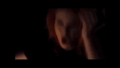 a person is holding a light bulb in a dark room .