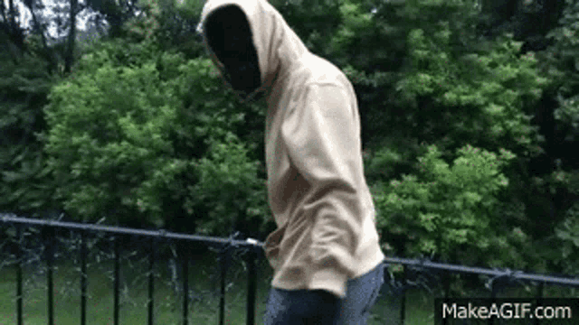 a man in a hooded sweatshirt is standing on a balcony .