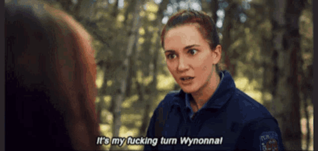 a woman in a police uniform is talking to another woman and says it 's my fucking turn wynonnal .