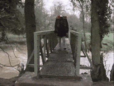 a person walking across a bridge with a backpack on