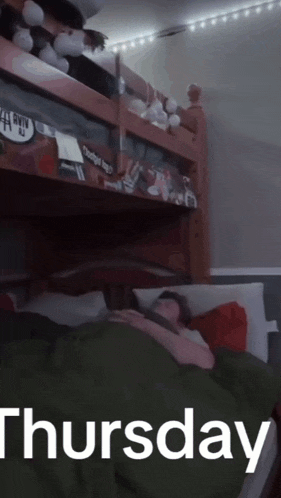 a person laying in a bunk bed with the date thursday on the bottom