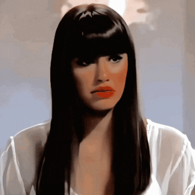 a woman with long hair and bangs looks at the camera