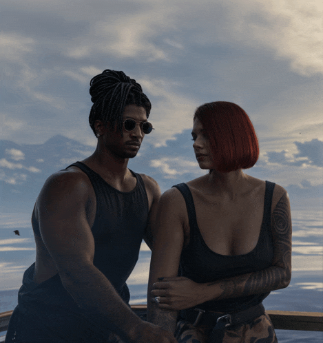 a man and a woman are standing next to each other in front of the ocean