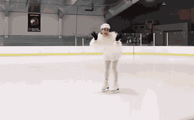 a woman in a white dress is ice skating on a rink