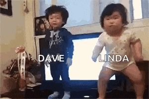a little boy and a little girl are dancing in front of a television .