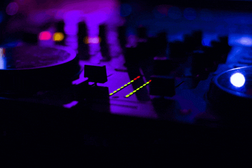 a blurred image of a dj mixer with purple and blue lights
