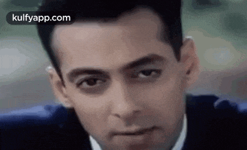 a close up of a man 's face in a suit and tie looking at the camera .