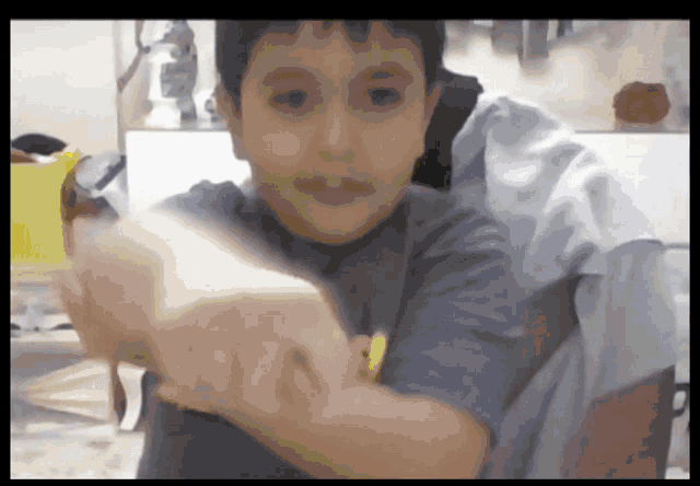 a young boy in a blue shirt with a yellow smiley face on it